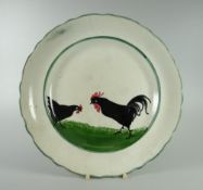 A LLANELLY POTTERY COCK & HEN DECORATED PLATE with slightly wavy border, marked LLANELLY to base,
