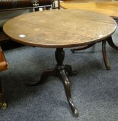 An antique oak circular top tripod table, 79cms diam