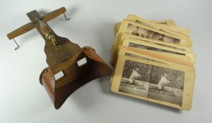 A turn-of-the-century wooden goggle-type photo slide-viewer with a quantity of associated