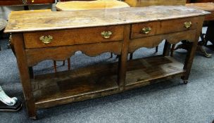 An antique oak Welsh dresser base with open platform & two drawers over a shaped frieze, 176cms