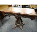 An antique mahogany fold-over card-table with baize lined interior having an elaborately carved