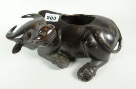 An Oriental bronze censer in the form of a reclining ox with opening located on the spine, 27cms