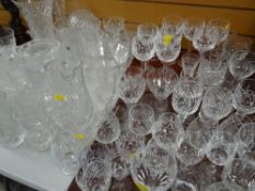 A large quantity of cut glass drinking glasses, cut glass vases, jugs, sundae dishes etc including