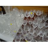 A large quantity of cut glass drinking glasses, cut glass vases, jugs, sundae dishes etc including