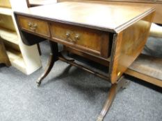 An antique-reproduction drop-flap cross-banded sofa-table (distressed)