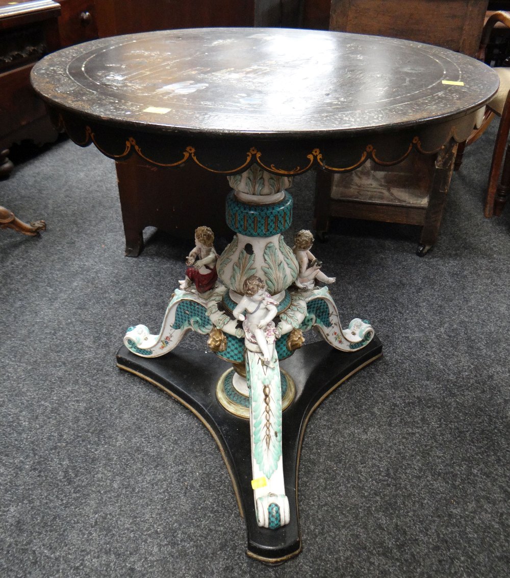 An unusual antique table having an Italianate porcelain & wooden painted cherubic tri-form base