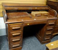 An antique American low roll-top desk with two banks of four drawers