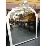 An antique white painted shaped mirror with putti & laurel decorative finial, 117cms high