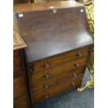 A small antique mahogany bureau composed of four graduated drawers, the sloped front revealing