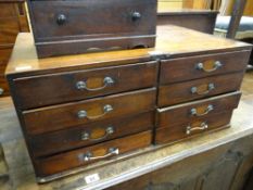 A vintage table top artist's chest with a bank of eight drawers having brass handles