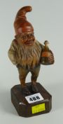 A small Black-Forest type carved and painted wood jolly elf-figure, carrying a jug