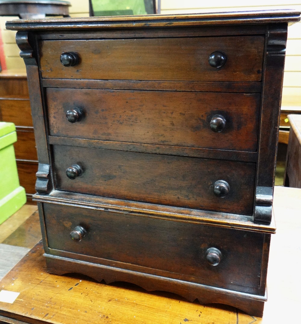 An antique mahogany miniature chest / apprentice chest of four graduated drawers with turned knobs &