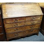An antique mahogany bureau composed of three long & two short drawers, the sloped front revealing an