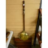Polished wall hanging rack in the Arts & Crafts style and a brass long handled bedwarming pan