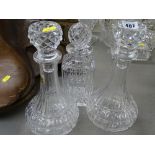 Pair of circular based glass decanters with stoppers and a square based glass decanter with stopper
