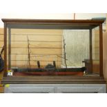 Model of a paddle boat steamer in a glass display case