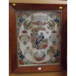 An antique woolwork sampler with the depiction of birds & flowers with needlework prose and