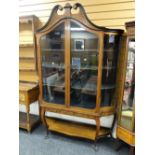 An attractive antique dome-top satinwood display cabinet having a frontage of two glazed doors &