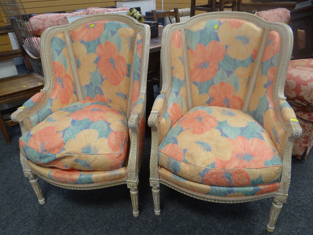 A pair of modern carved French-style elbow chairs with bright floral upholstery Condition Report: