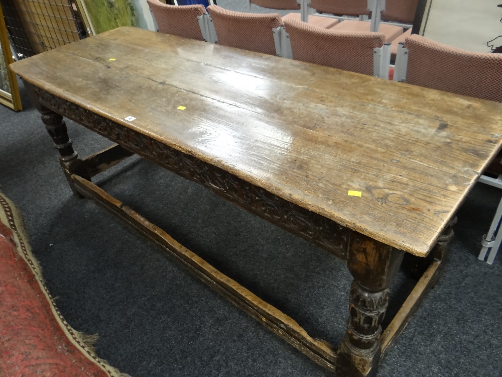 A believed eighteenth century carved oak refectory table, the top with three planks, carved frieze