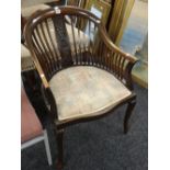 A twentieth century mahogany spindle back tub-type chair with serpentine front & tapestry seat