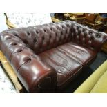 A two-seater cherry coloured leather Chesterfield settee Condition Report: please request via email.