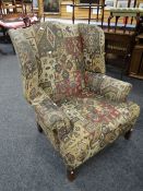 A good vintage wing-back fire-side armchair in geometric Aztek-type patterned upholstery Condition