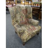 A good vintage wing-back fire-side armchair in geometric Aztek-type patterned upholstery Condition