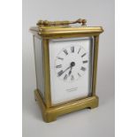 A brass encased carriage clock with white dial bearing Roman numerals & inscribed Arnold & Lewis,