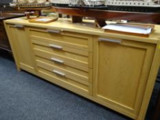 A modern oak sideboard composed of four centre drawers & flanking cupboards, 210cms wide Condition
