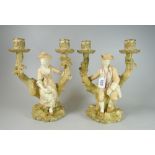 A PAIR OF ROYAL WORCESTER FIGURALTWIN CANDLE-HOLDERS in the form of lady and gentleman seated on
