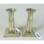PAIR OF SILVER PLATED DWARF/SMALL CANDLESTICKS having swag and bow decoration raised on square