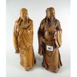TWO SIMILAR CARVED HARDWOOD FIGURES OF CHINESE OFFICIALS one holding book, the other holding his