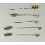 FIVE YELLOW METAL TIE PINS to include gold, smoky quartz, flower head diamond, emerald etc