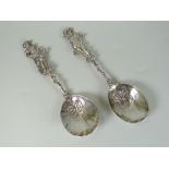 PAIR OF CONTINENTAL SILVER FIGURAL SPOONS having floral and foliate decorated bowls terminating with