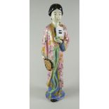 JAPANESE PORCELAIN FIGURINE OF A STANDING FEMALE holding bird & fan in flowing robes, unglazed &