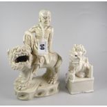 CHINESE BLANC DE CHINE FIGURE OF POSSIBLY A LUOHAN OR ARHAT sitting on dog of foo together with