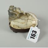 WHITE HARDSTONE STUDY OF A HORNED BEAST raised on hardwood stand, 6cms high Condition Report: