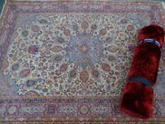 A modern tufted wool rug & a vintage-style tassel ended woollen rug, floral patterned on a cream red