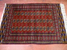 An antique-style red ground woollen carpet