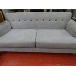 An ultra modern upholstered settee with colourful button back detail