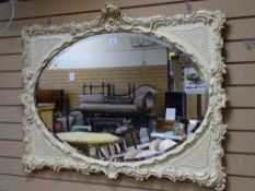 A Victorian painted Rococo-style oval bevel edged wall mirror
