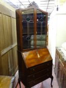 A vintage walnut full front bureau bookcase with leaded glass top doors