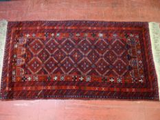 An antique-style red ground woollen carpet