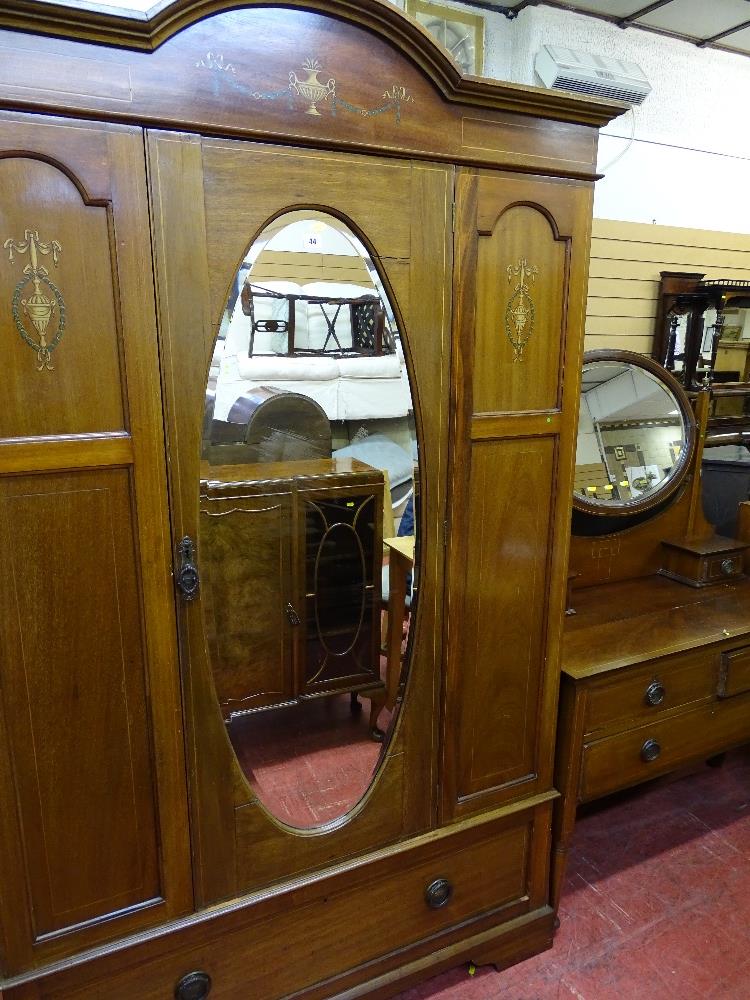 A circa 1900 two-piece line inlaid mahogany bedroom suite, the central mirrored wardrobe with