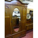 A circa 1900 two-piece line inlaid mahogany bedroom suite, the central mirrored wardrobe with