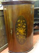A good small reproduction bow front hanging wall cupboard with inlaid floral cartouche
