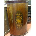 A good small reproduction bow front hanging wall cupboard with inlaid floral cartouche