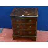 A reproduction serpentine front three-drawer chest