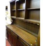 Dark wood dresser with sectional top and carved detail to base cupboards